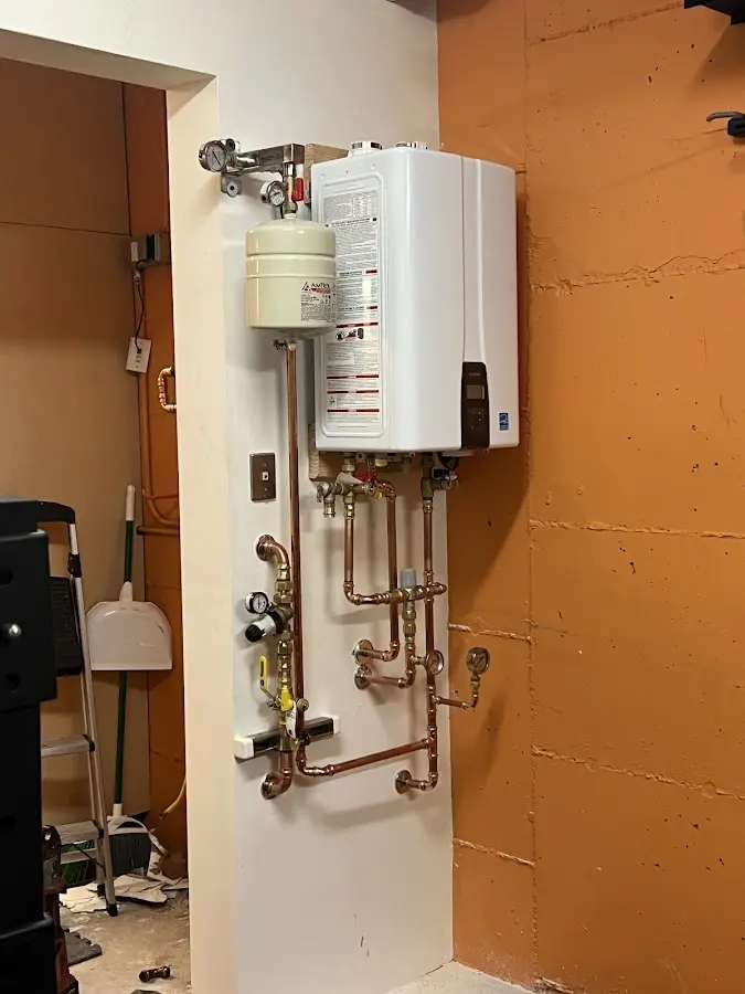 Plumbing technician inspecting water heater connections in Lorton